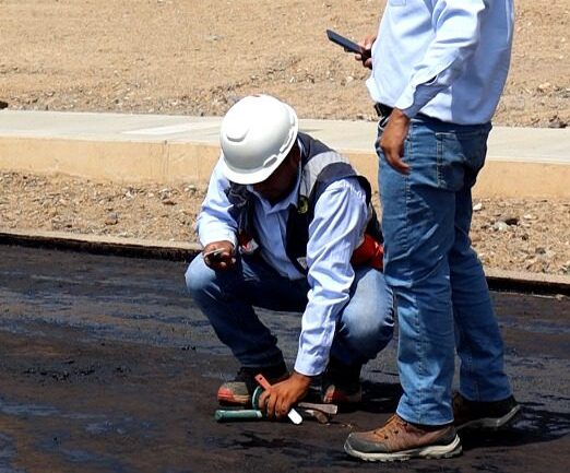 Técnico de Asfaltec Perú revisando trabajo de asfaltado en obra